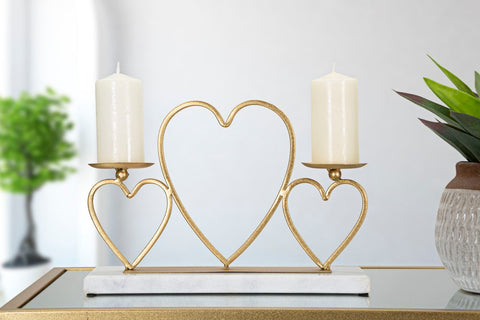 Candelabro de metal dorado con base de mármol blanco y corazones