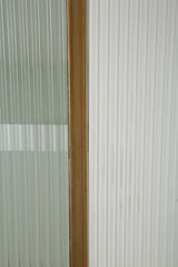 Vitrine design arrondi en bois blanc et inserts en bois brun avec 2 portes et 2 tiroirs