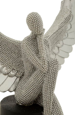 Estatuilla plateada con alas extendidas