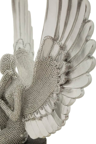 Estatuilla plateada con alas extendidas