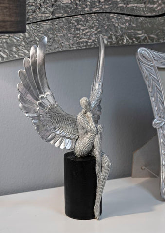 Estatuilla plateada con alas extendidas